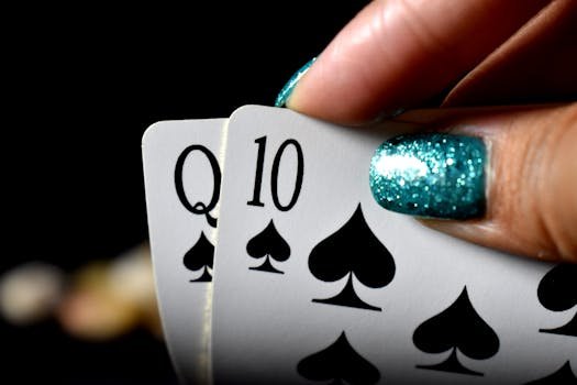 pexels photo 2444580 2444580 Intense close-up of a hand holding Queen and Ten of spades in a poker game.